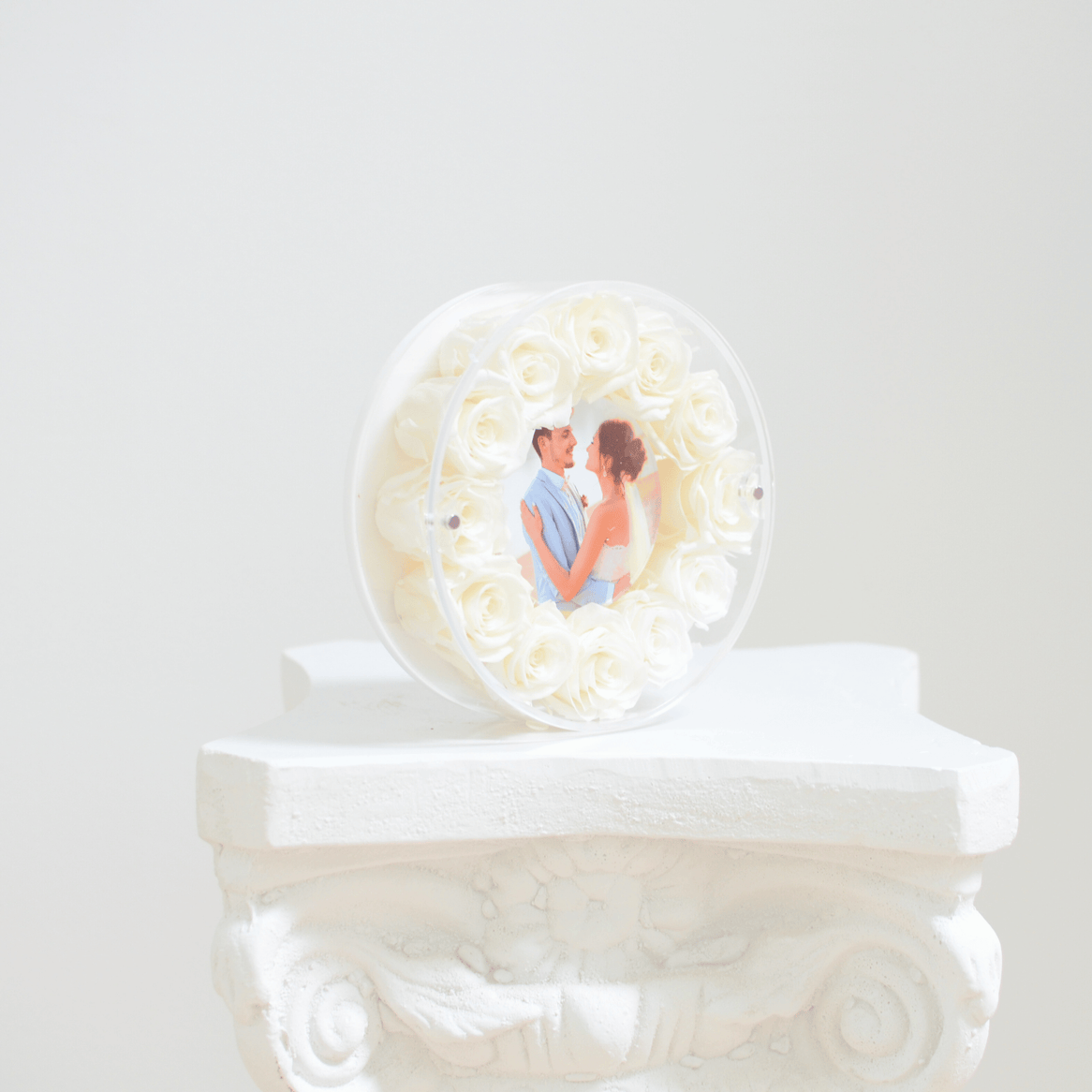 round picture frame with white preserved roses