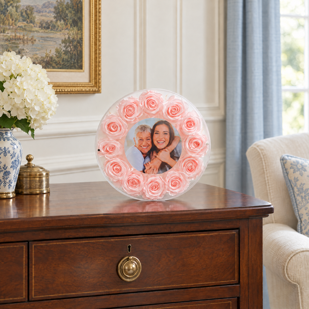 Blush large Halo preserved rose photo frame, front view, standing on a wood console