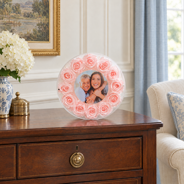 Blush large Halo preserved rose photo frame, front view, standing on a wood console